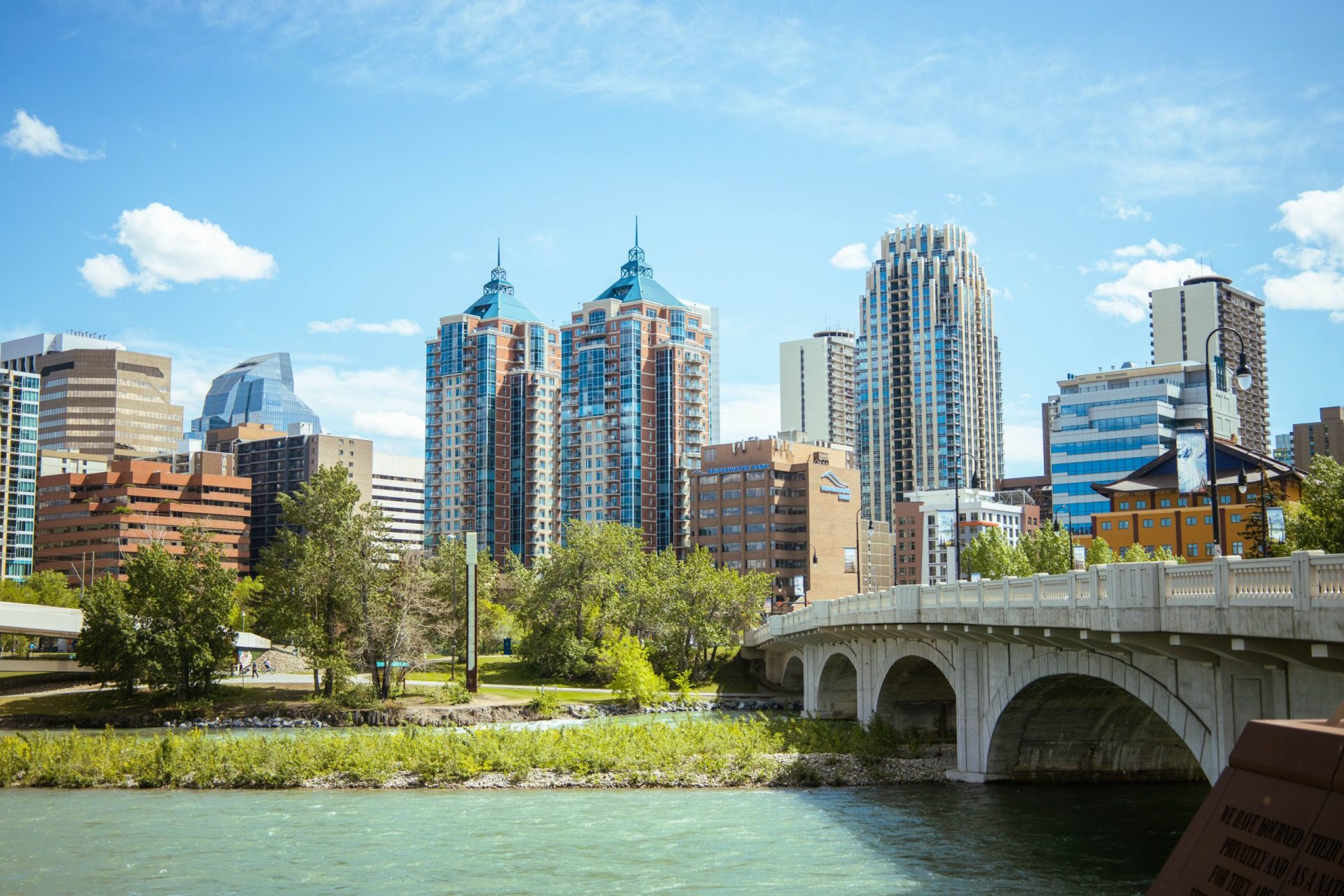a bridge over the river in a city surrounded by tall buildings